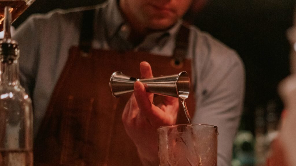 This photo displays our head bartender pouring a cocktail in our popular cocktail making class in NYC